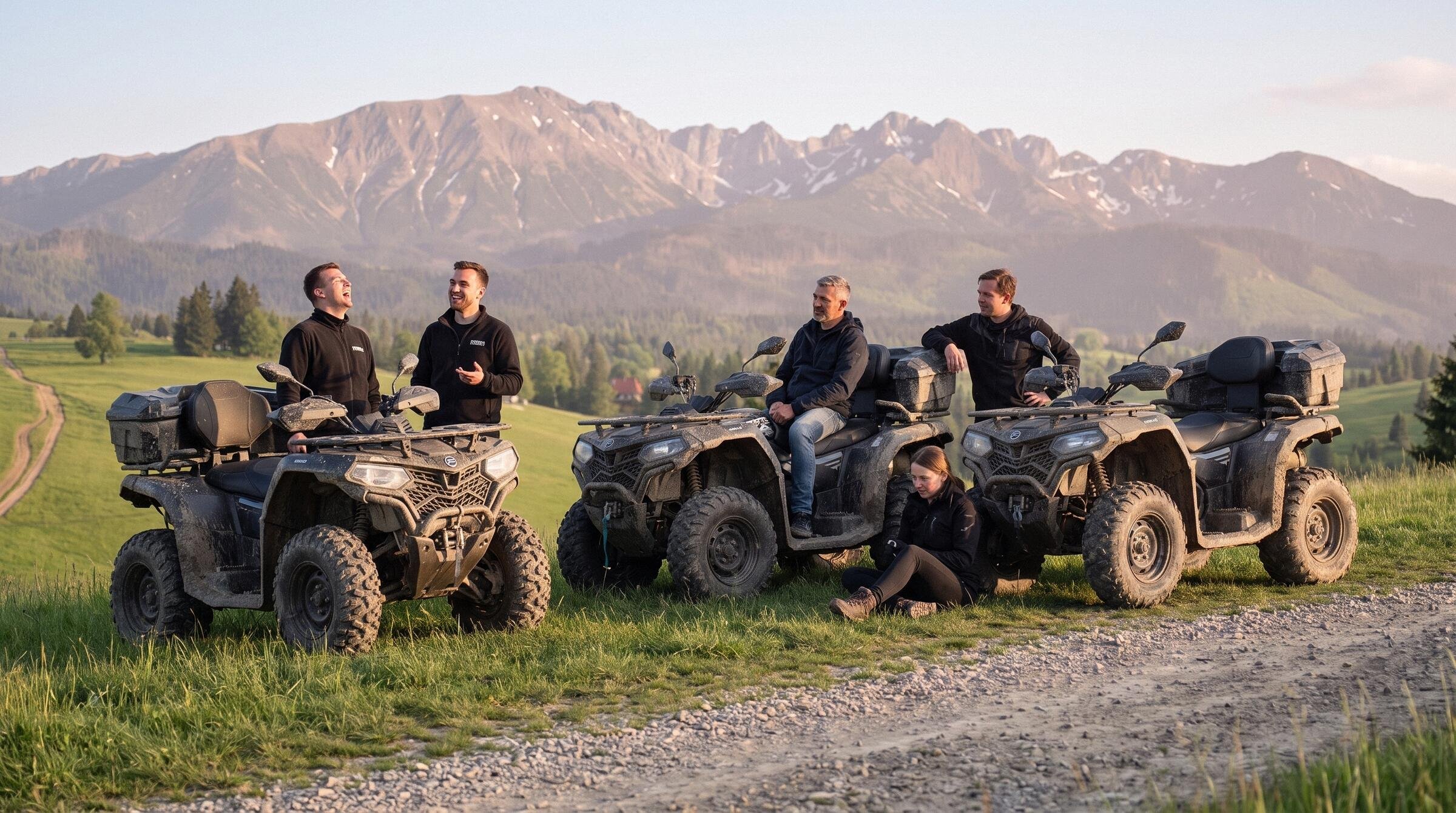Pięć osób odpoczywa przy trzech zabłoconych quadach nad szutrową drogą o złotej godzinie, za nimi Tatry w ciepłym świetle